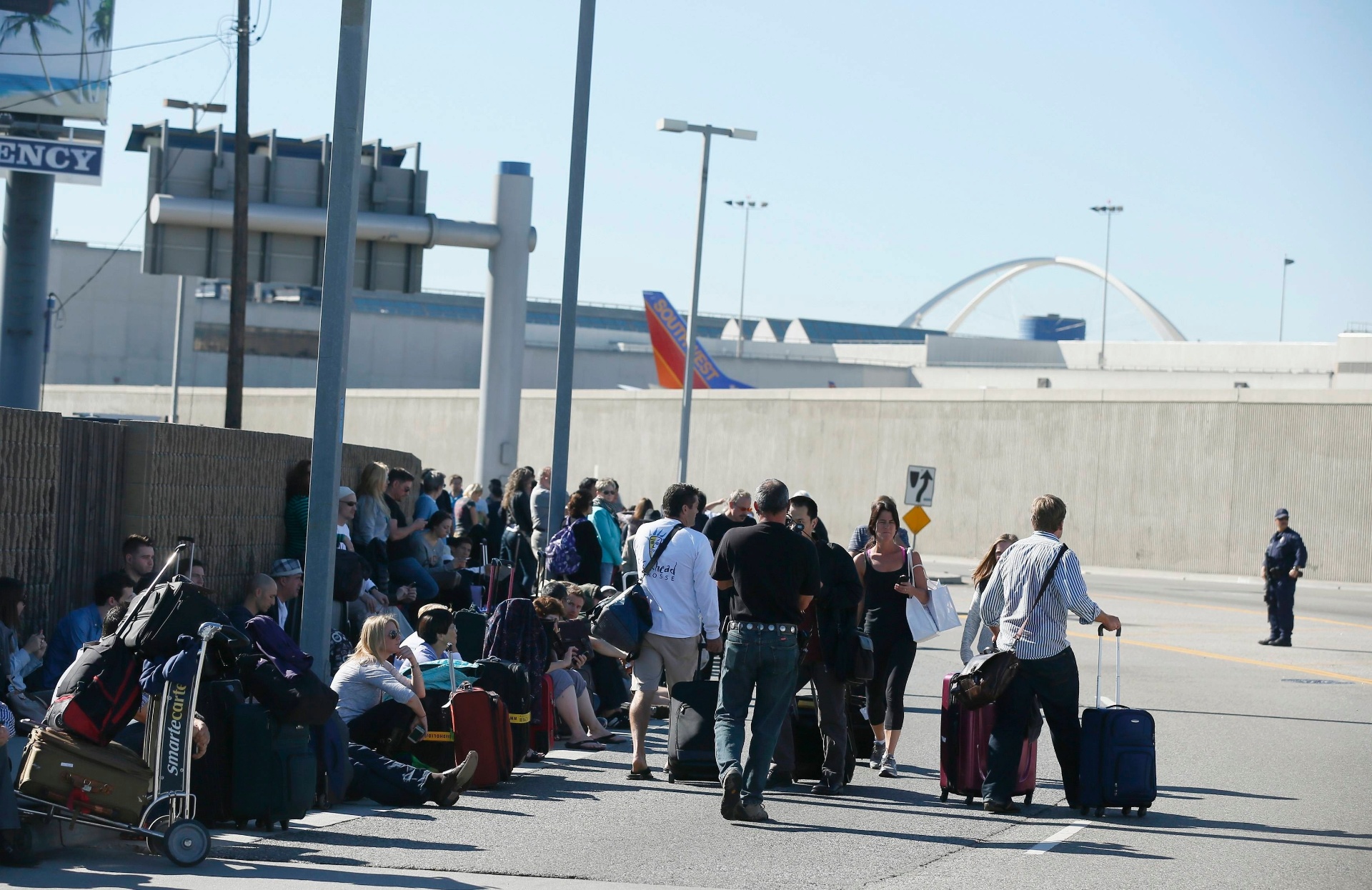 1º.nov.2013 - Passageiros evacuam o aeroporto internacional de Los Angeles, nesta sexta-feira (1). O local foi esvaziado na manhã desta sexta-feira (1) após um tiroteio no Terminal 3. Um homem teria disparado com um fuzil e pelo menos três pessoas teriam ficado feridas, entre eles um agente federal - Lucy Nicholson/Reuters