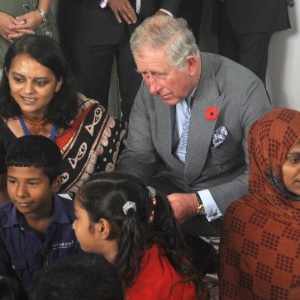 O príncipe britânico Charles (segundo à esq.) e sua mulher, Camilla (terceira à dir.), cumprimentam crianças indianas durante visita a uma creche em Mumbai - Indranil Mukherjee/AFP