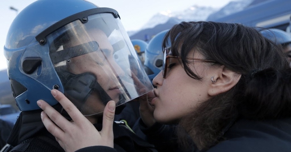 16.nov.13 - Manifestante beija um policial neste sábado (16) durante uma passeata contra o Trem de Alta Velocidade em Susa, na Itália. O trem vai ligar Lyon e Turim, e deve ficar pronto em 2025