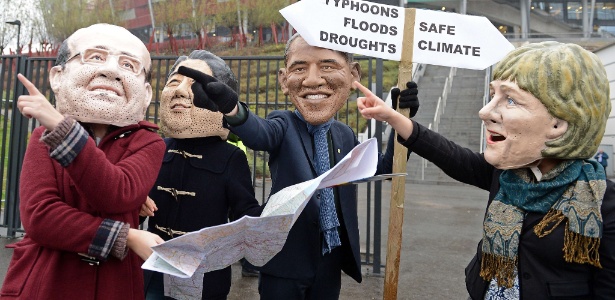 Ativistas usando máscaras  de líderes mundiais discutem qual direção de clima seguir em protesto em frente ao local onde acontecia a Conferência da ONU sobre Mudanças Climáticas, em Varsóvia - 22.nov.2013 - Janek Skarzynsky/AFP