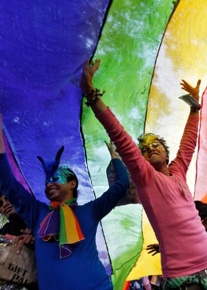Meninas brincam com bandeira com as cores do arco-íris, símbolo no movimento gay, em Nova Delhi, na Índia - Mansi Thapliyal/Reuters