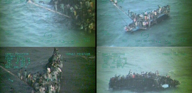 Na série de imagens fornecidas pela Guarda Costeira dos EUA, cerca de 100 haitianos agarram casco de um cargueiro que naufragou na costa de Staniel Clay, nas Bahamas - Guarda Costeira dos EUA/AFP