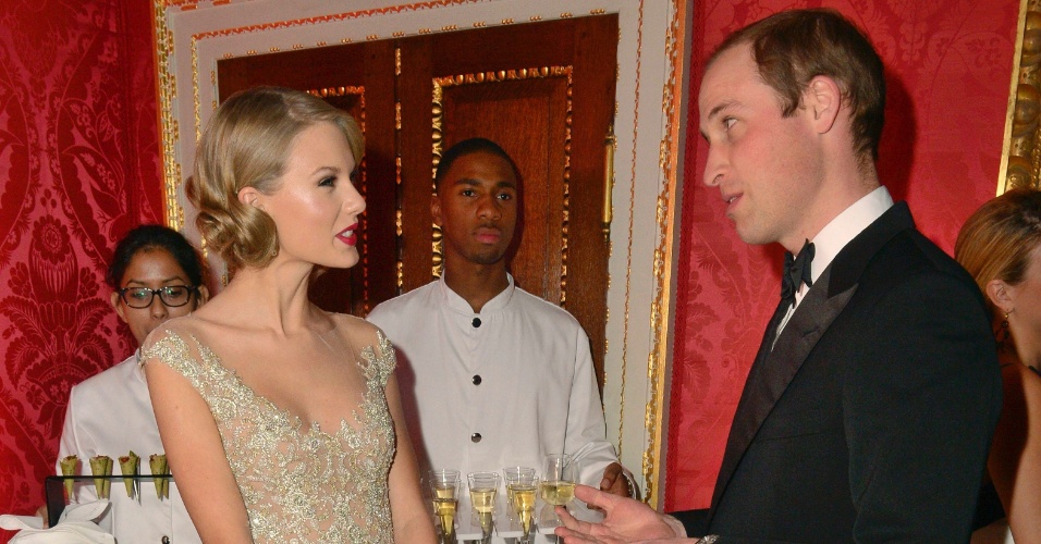 26.nov.2013 - O príncipe William, duque de Cambridge, conversa com a cantor Taylor Swift durante o Centrepoint Gala Dinner, no palácio Kensington, em Londres, nesta terça-feira (26)
