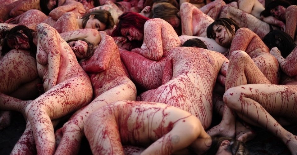 01.dez.2013 - Ativistas do grupo "Anima Naturalis", que defende os direitos dos animais, protestam nus e cobertos de sangue falso contra o uso de couro e peles na indústria têxtil, em Barcelona