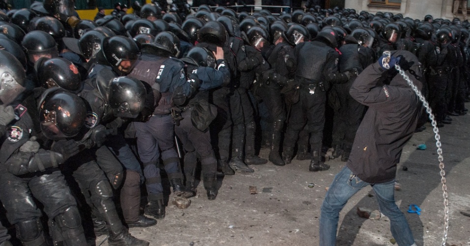 2.dez.2013 - Manifestante enfrenta policiais durante protesto contra a decisão do presidente ucraniano, Viktor Yanukovych, de suspender um acordo comercial com a UE (União Europeia), em frente à sede do governo, em Kiev