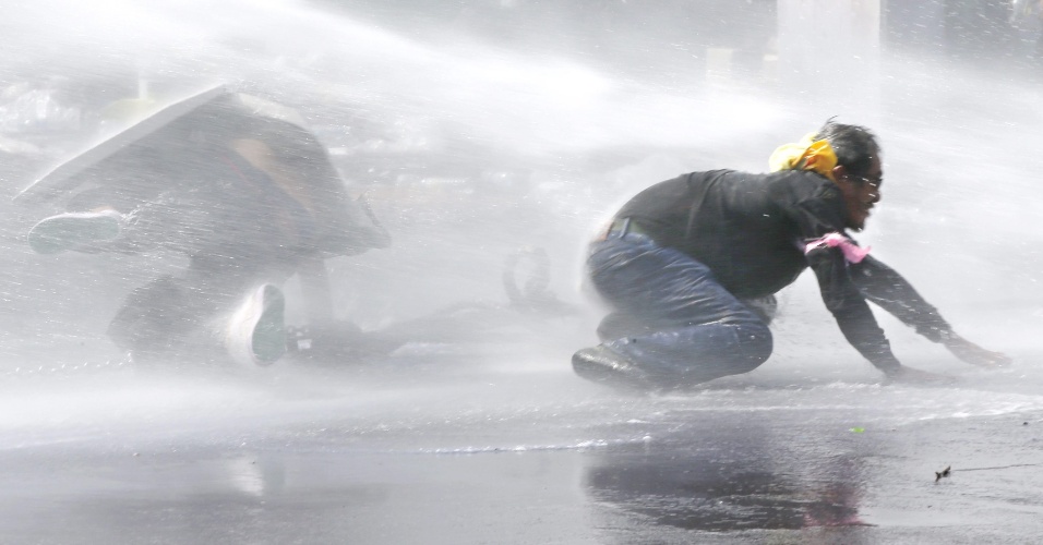 2.dez.2013 - Manifestantes antigoverno são atingidos por jatos de água química lançados pela polícia de Bangcoc (Tailândia)