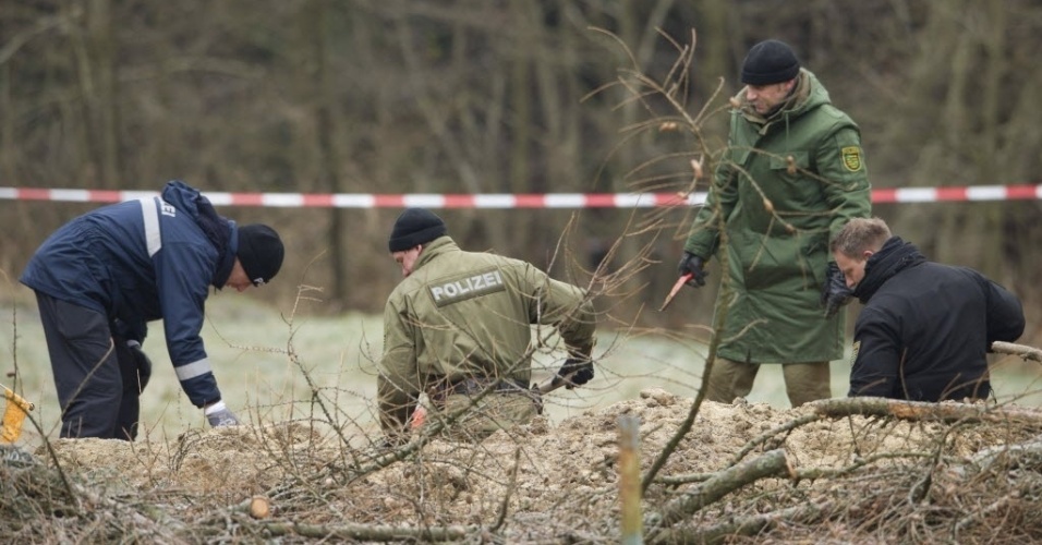 4.dez.2013 - Policiais escavam o jardim de uma casa em Reichenau, Alemanha. Um agente de polícia confessou ter matado uma pessoa que o pediu e em seguida ter enterrado o corpo em seu jardima