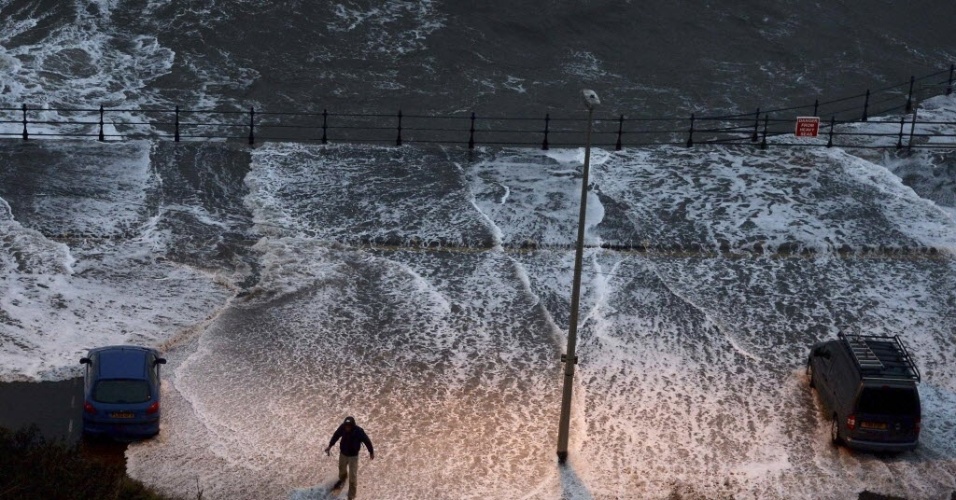 05.dez.2013 - Homem caminha em pier alagado em Scarborough, no norte da Inglaterra. Fortes ventos interromperam o fornecimento de energia na Escócia e deixaram cidades da Inglaterra em alerta para enchentes. Meteorologistas acreditam que a tempestade prevista para os próximos dias na região pode ser a mais forte em anos