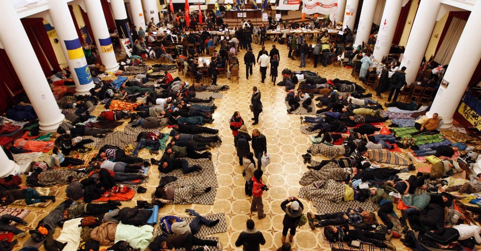 5.dez.2013 - Manifestantes descansam nesta quinta-feira (5) no edifício da Prefeitura de Kiev (Ucrânia), ocupado no domingo (1º)