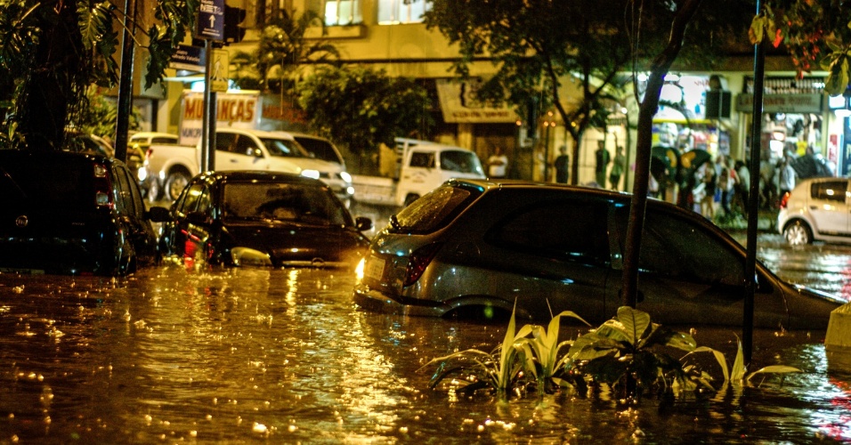 6.dez.2013 - Carros ficam parcialmente encobertos em rua inundada durante chuva forte no Rio de Janeiro