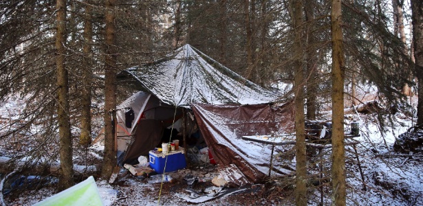 Área de acampamento abandonada fica coberta de neve em Soldotna, Alasca (EUA). Acampar é  um estilo de vida e parte dos costumes no Alasca, onde morar em uma barraca no meio do mato pode ser uma escolha ou, por outro lado, a única opção entre os que não têm casa, um problema "escondido" no Estado  - Nicole Bengiveno/The New York Times