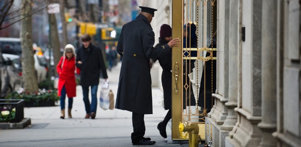 Porteiro trabalha na Park Avenue, em Manhattan, Nova York (EUA).  No fim do ano é comum que os moradores dos prédios entreguem envelopes recheados de gorjetas aos porteiros - Joshua Bright/The New York Times