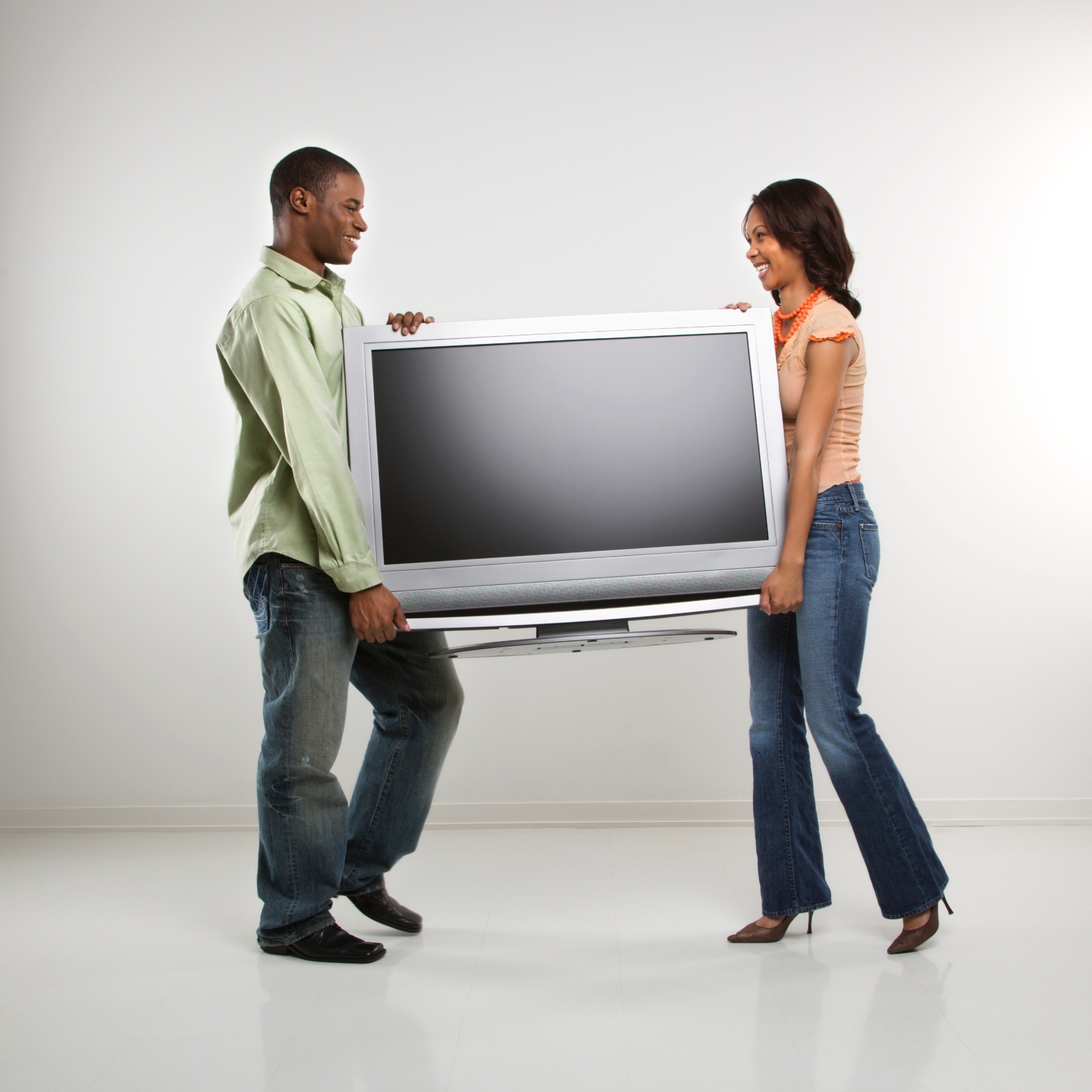 Casal carrega televisão; casal carrega TV; compra de TV; televisor; televisão; TV - Getty Images