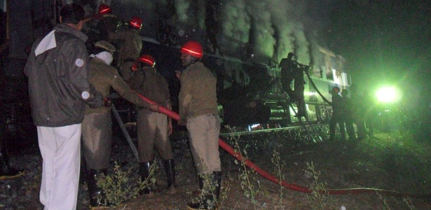 Bombeiros tentam conter incêndio em trem em ferrovia perto de Puttapartihi (Índia) - AFP