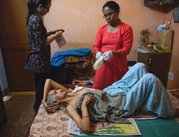 Enfermeiras cuidam de Sudershan Talwar, paciente com câncer de mama, em Nova Deli, na Índia - Lynsey Addario/The New York Times