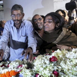 2.jan.2014 - Pais de uma jovem que sofreu dois estupros coletivos em ataques separados colocam flores junto ao corpo em Calcutá, Índia