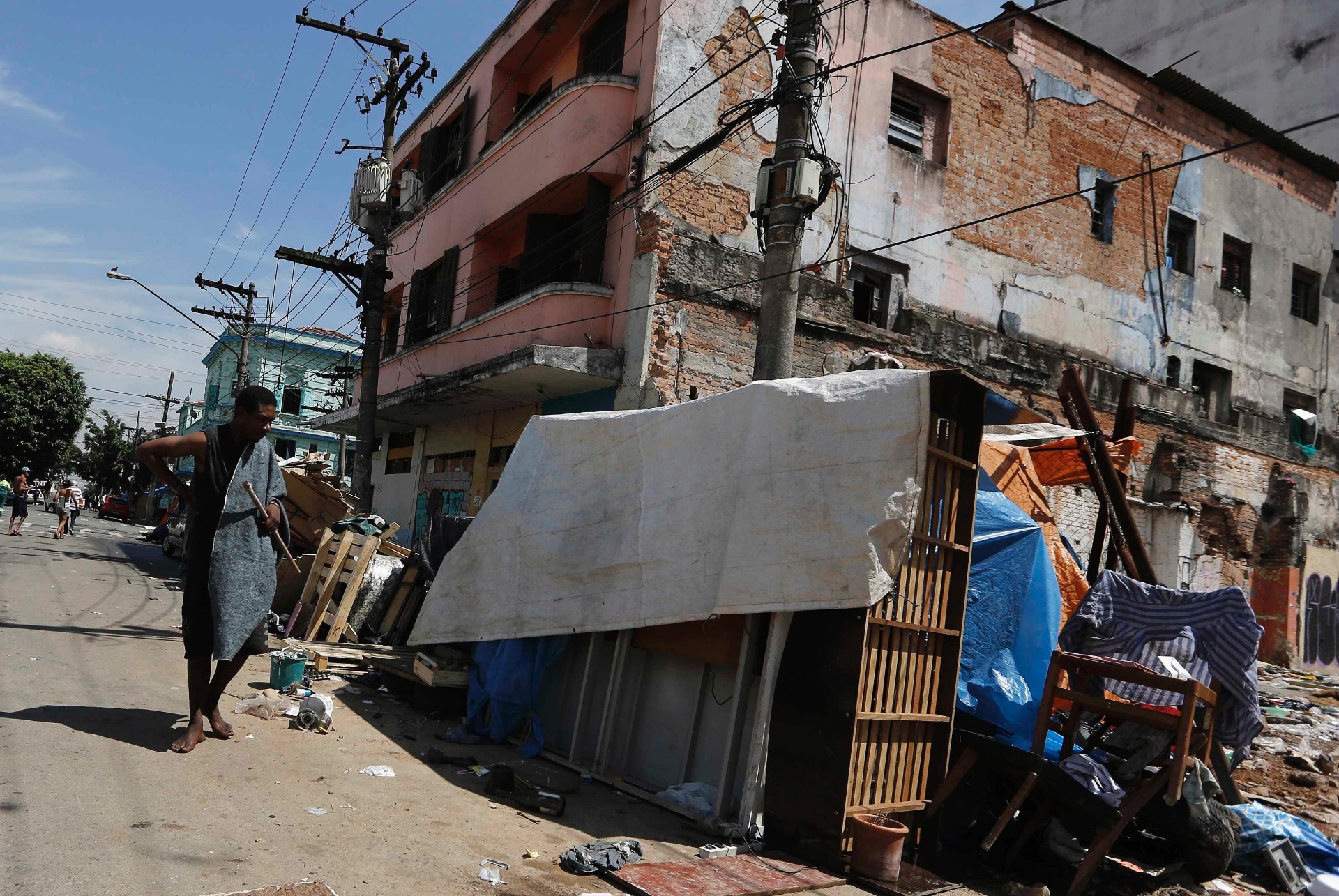 14.jan.2014 - Um homem caminha próximo a um barraco, no bairro da Luz, região central de São Paulo, em local conhecido como Cracolândia, nesta terça-feira (14). A prefeitura iniciou nesta terça-feira (14) a retirada barracos erguidos na calçada da alameda Dino Bueno. Os sem-teto deixaram o local pacificamente e estão sendo levados para um hotel na esquina da Dino Bueno com a rua Helvétia. A operação estava marcada para amanhã, mas foi antecipada porque, sabendo que seriam removidos, os próprios sem-teto iniciaram o desmonte dos barracos nesta manhã. A ação faz parte do programa Operação Trabalho, que prevê o pagamento de R$ 15 por dia aos usuários em troca de quatro horas de trabalho, mais duas horas de requalificação profissional - Nacho Doce/Reuters