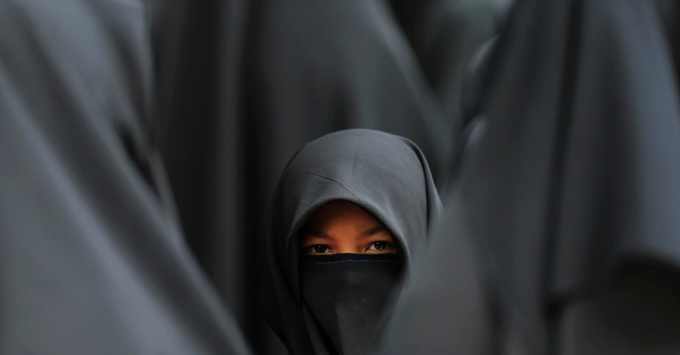14.jan.2014 - Uma menina vestindo um hijab espera no estádio Shah Alam durante as celebrações de Maulidur Rasul, ou o nascimento do Profeta Muhammad, em Kuala Lumpur, na Malásia