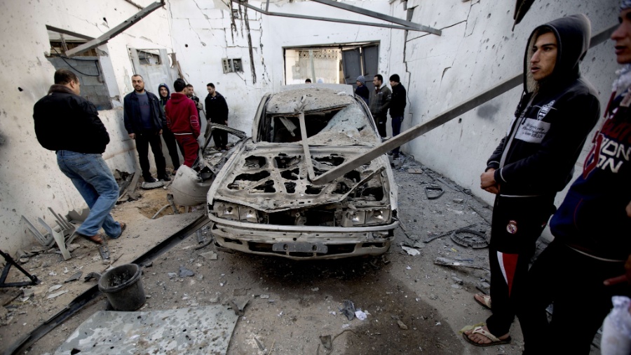 16.jan.2014 - Palestinos se reúnem ao redor de carro destruído após ataque aéreo de Israel à faixa de Gaza. De acordo com fontes locais, quatro crianças e uma mulher ficaram feridos durante os ataques, que aconteceram na madrugada desta quinta-feira. Israel afirma que o ataque foi a campos de treinamento utilizados pelo grupo Hamas