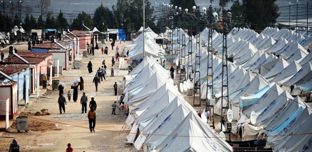 Refugiados sírios caminham entre as tendas do campo de Karkamis, próximo à cidade de Gaziantep, no sul da Turquia. Todos os dias, centenas de sírios chegam ao local fugindo da guerra civil síria - 16.jan.2014 - Ozan Kose/AFP