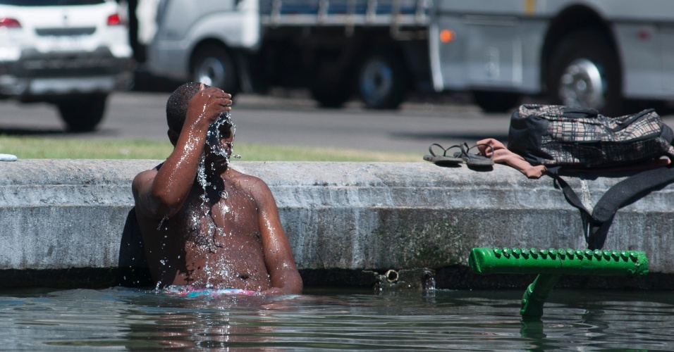 22.jan.2014 - Homem se banha no chafariz da Candelária, no Centro do Rio, para escapar da sensação térmica de mais de 40 graus da cidade, nesta quarta feira (22)