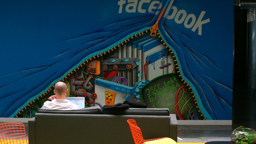 Funcionário do Facebook trabalha com computador em sofá na sede da empresa em Menlo Park, na Califórnia (EUA) - Robert Galbraith/Reuters