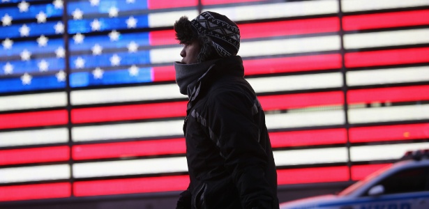 Homem passa por um luminoso com a bandeira americana em Times Square, Nova York. Em pesquisa da BBC, os Estados Unidos foram apontados como a nação mais perigosa, bem à frente do Paquistão