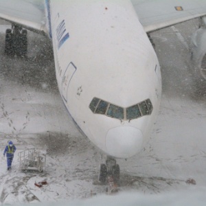 Avião da ANA (All Nippon Airways) é coberto pela neve enquanto permanece estacionado no aeroporto de Haneda