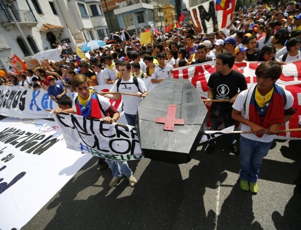 Opositores ao governo da Venezuela seguram um caixão de papelão durante uma manifestação contra o governo do presidente Nicolás Maduro, em Caracas 