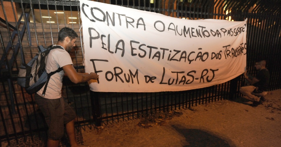 13.fev.2014 - Manifestantes ajeitam faixa contra o aumento da passagem de ônibus durante protesto no centro do Rio de Janeiro, nesta quinta-feira (13). Pelo menos mil pessoas participam do ato, que segue pacífico