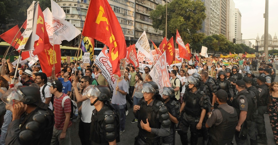 13.fev.2014 - Policiais acompanham cerca de mil manifestantes que saíram em passeata pelo centro do Rio de Janeiro em um novo protesto contra o aumento da tarifa de ônibus na cidade