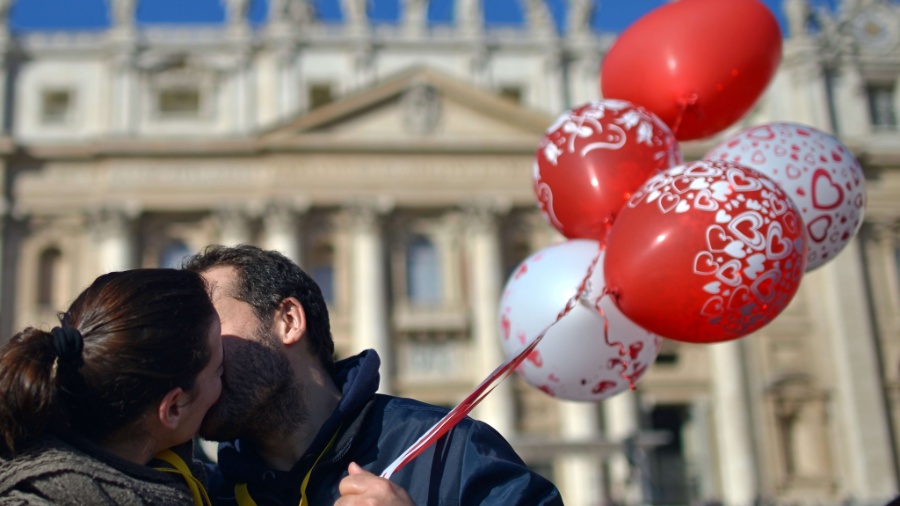 14.fev.2014 - Um casal de noivos se beija na praça de São Pedro, no Vaticano - Gabriel Bouys/AFP
