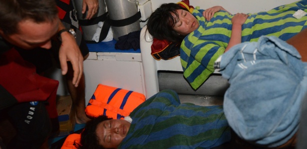 Duas mergulhadoras japonesas são trazidas para o barco em operação de resgate em Denpasar, na ilha de Bali, na Indonésia, nesta segunda-feira (17). No total, cinco mergulhadores japoneses foram encontrados vivos agarrados a um coral três dias após serem dados como desaparecidos - Sonny Tumbelaka/AFP