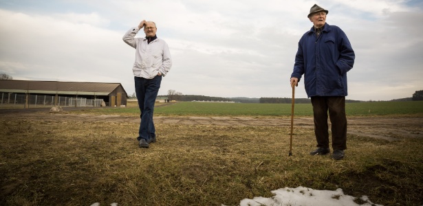Ulrich Schulz (e) e seu pai Guenter trabalham na fazenda da família que pode ser arrasada pela expansão de uma mina de carvão em Atterwasch, na Alemanha - Gordon Welters/The New York Times
