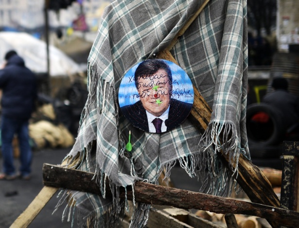 25.fev.2014 - Uma foto do ex-presidente ucraniano Viktor Yanukovych foi colada em uma placa de dardo na praça da Independência, em Kiev - Bulent Kilic/AFP