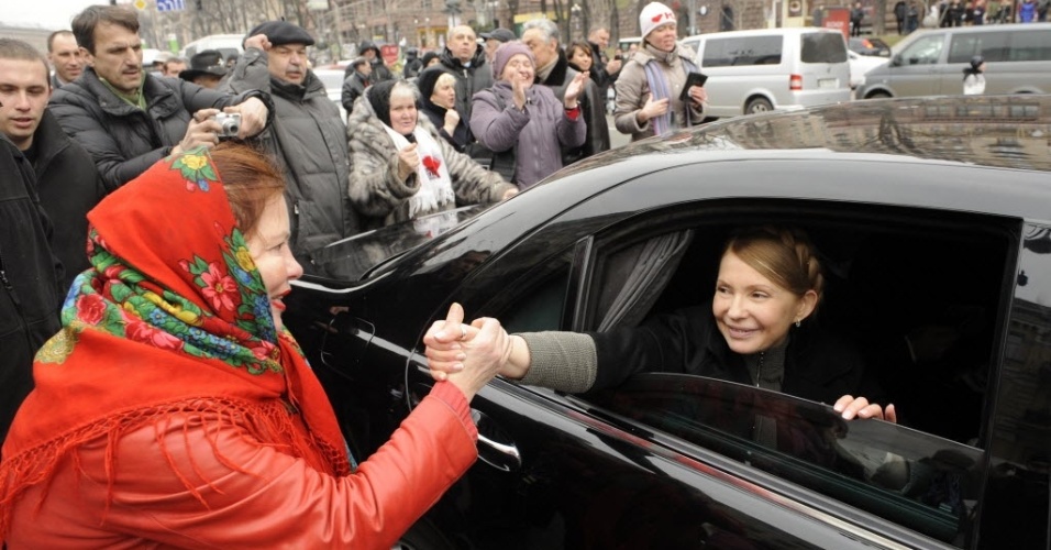 28.fev.2014 - A líder da oposição ucraniana, Yulia Timoshenko, cumprimenta mulher ao chegar a um acampamento de manifestantes antigoverno no centro de Kiev. Timoshenko, que ficou presa por mais de dois anos e foi libertada no sábado, com a queda do governo de Yanukovich, é vista como uma das favoritas à presidência do país 