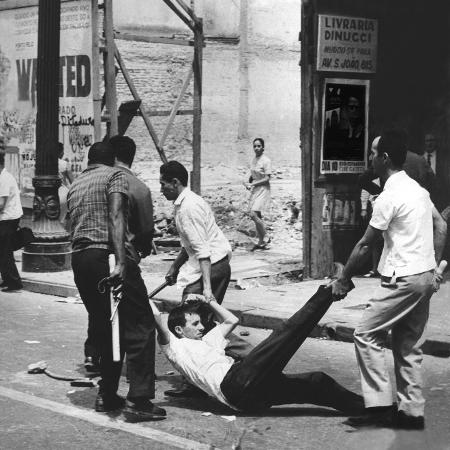 Um manifestante é preso por agentes policiais, em 1968, durante manifestação no centro da cidade de São Paulo - José Nascimento/Folhapress