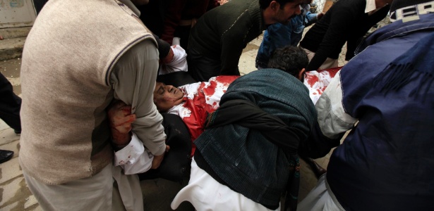 Pessoas socorrem homem ferido em atentado à bomba ao tribunal distrital de Islamabad, no Paquistão