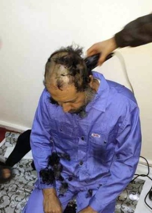 O terceiro filho de Muammar Gaddafi, Saadi Gaddafi, tem os cabelos raspados após ser entregue