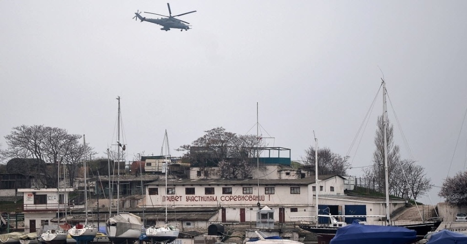 7.mar.2014 - Um helicóptero militar russo MI24 voa sobre o porto de Sebastopol, na Ucrânia, nesta sexta-feira (7). Observadores militares da OSCE, que foram impedidos de entrar Crimeia ontem vão fazer novas tentativas para entrar na península do mar Negro, nesta sexta-feira