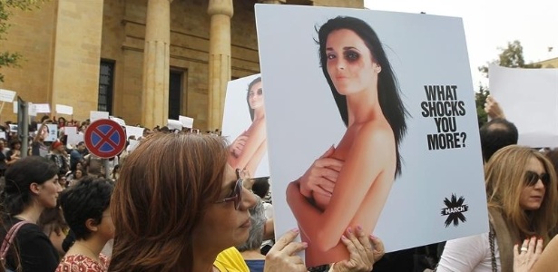 Libanesa da ONG Sociedade Civil mostra cartaz durante manifestação para exigir lei para proteger mulheres contra a violência doméstica