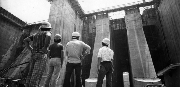 Trabalhadores observam obras da hidrelétrica Itaipu, cuja construção começou em 1974 - Folhapress