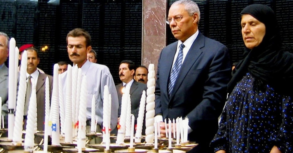 U.S. Secretary of State Colin Powell (2nd R) and Suhayba Abdul-Rahman, who lost her husband, all of her five children, and was blinded by a March 1988 chemical gas attack, light candles at a memorial built on a mass grave in the northern Iraq town of Halabja, September 15, 2003. Powell on Monday lit candles for victims of a 1988 chemical weapons attack on Iraqi civilians and told their families such an attack would never happen again