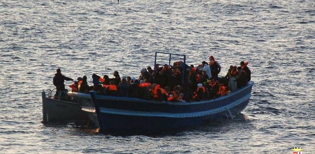 Imigrantes aguardam resgate em bote próximo à ilha de Lampedusa, na Itália - 18.mar.2014 - AFP