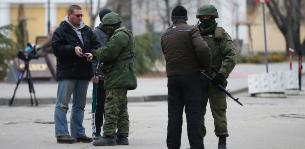 Homens armados sem identificação checam a documentação de jornalistas em Simferopol, na Crimeia - David Mdzinarishvili