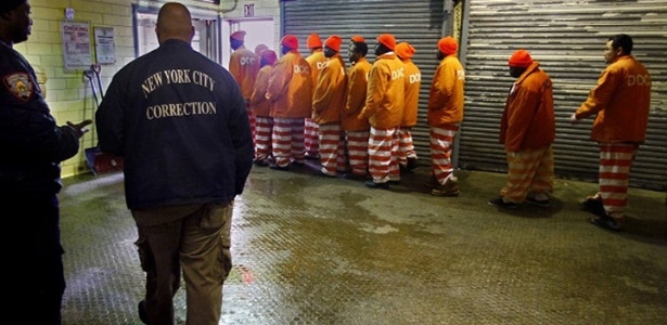 Detentos caminham no presídio de Rikers Island, instalado em uma ilha de Nova York - AFP