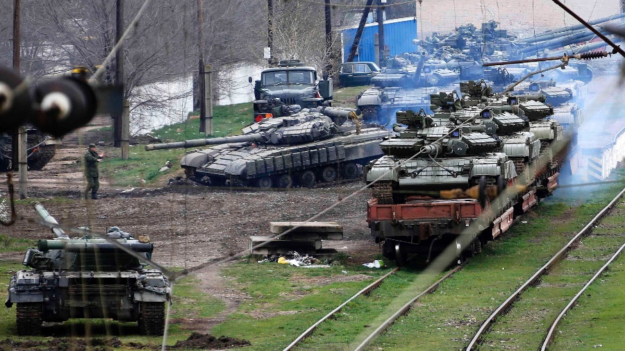 27.mar.2014 - Soldado russo (à esq.) orienta tanque ucraniano que será carregado em trem, no norte da Crimeia - Yannis Behrakis/Reuters