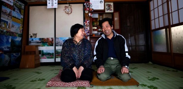 Casal que havia sido evacuado da área de Miyakoji, em Tamura (Japão) há três anos, sorri depois de voltar para casa - Issei Kato/Reuters