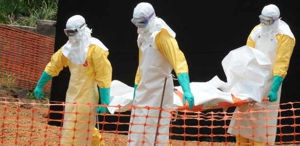 1º.abr.2014 - Membros da organização Médicos Sem Fronteiras carregam corpo de pessoa morta por febre hemorrágica em centro para doentes infectados com o vírus ebola, em Guekedou, em Guiné - AFP