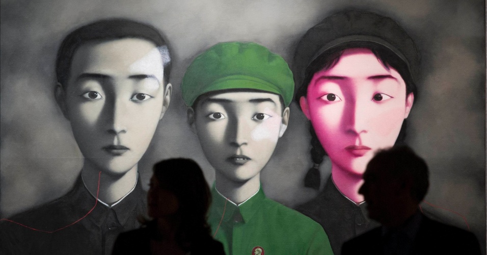 02.abr.2014 - Visitantes andam na frente do quadro do artista chinês Zhang Xiaogang "Bloodline: Big Family No.3", durante a exposição da Primavera de Vendas da Sotheby em Hong Kong, na China